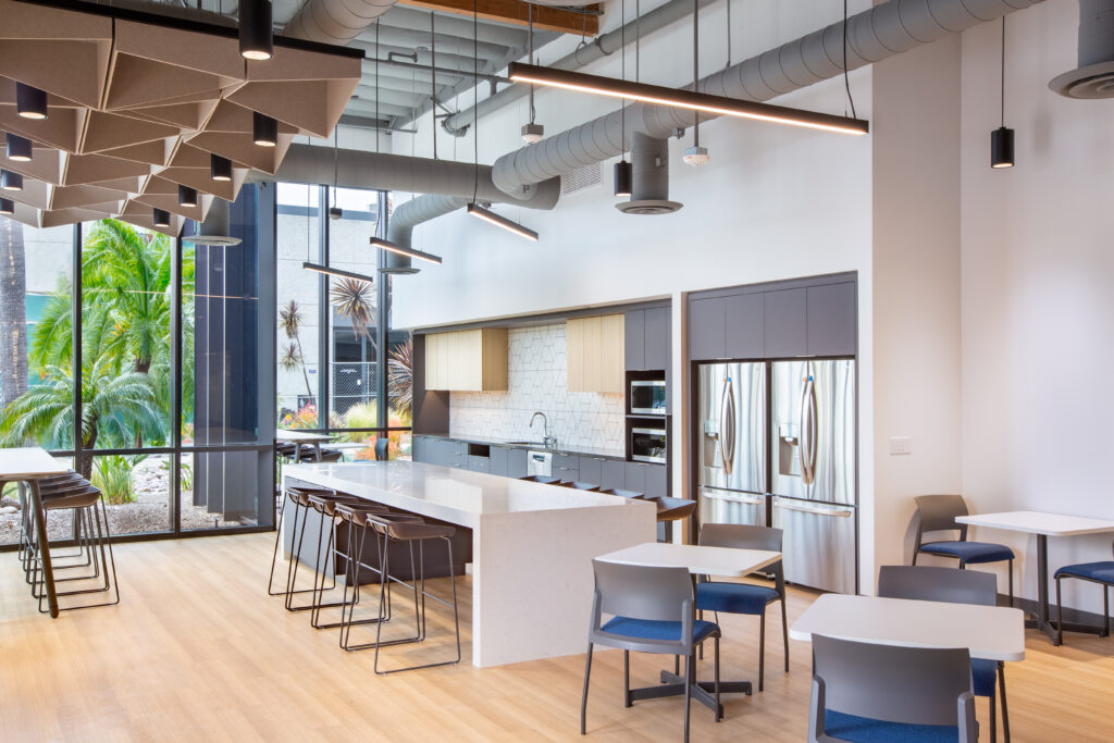 Genalyte at CenterPark Kitchen area, with tables and chairs, two fridges, big windows with plenty of natural light coming in